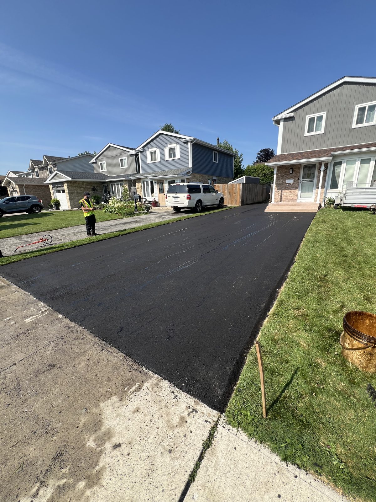 Freshly paved smooth black asphalt residential driveway leading to a suburban home in the Greater Toronto Area